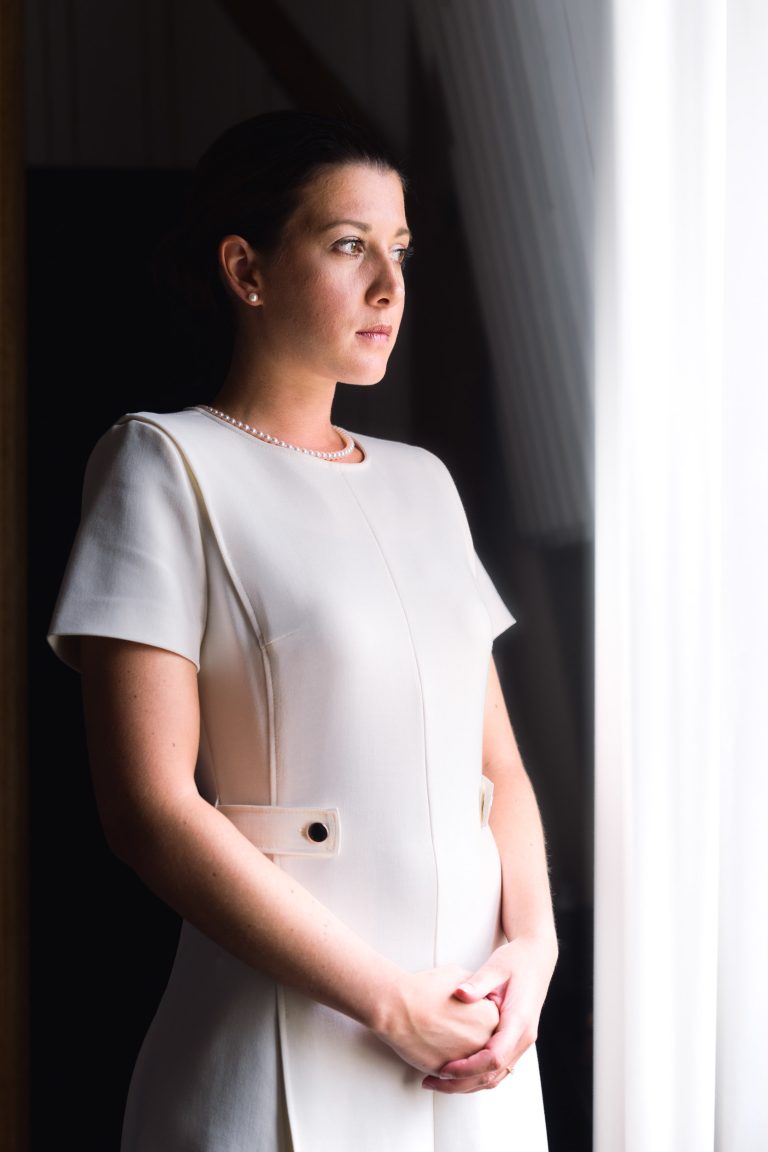 Valentine, la mariée, se tient gracieusement dans une robe blanche au Château de Garde à Moulon.